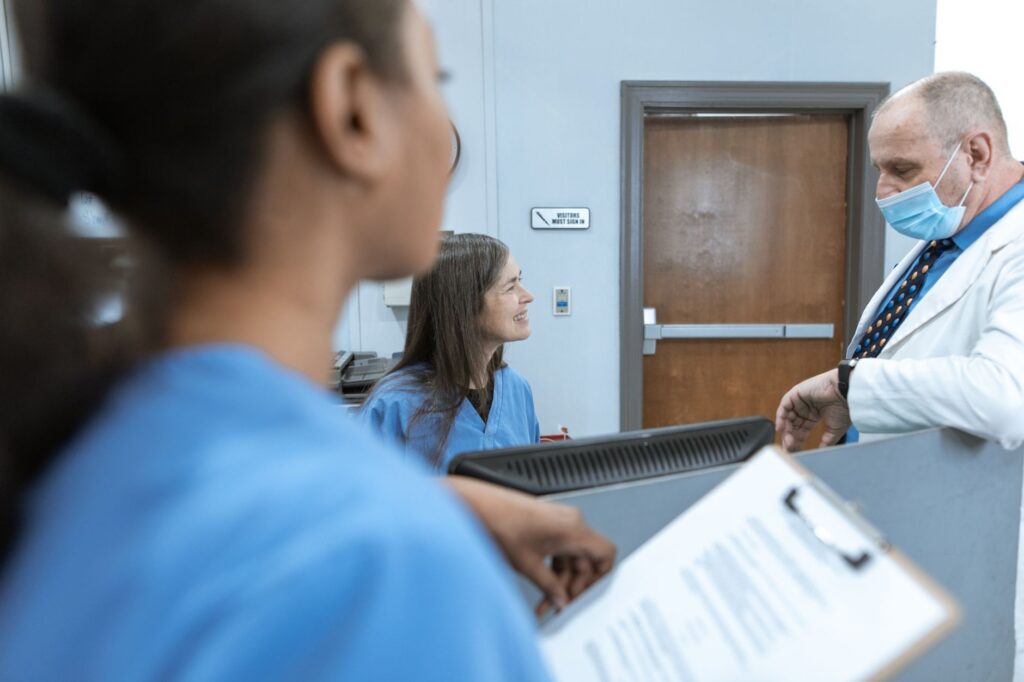 Une soignante échange avec des collègues dans le couloir d'un centre de soins