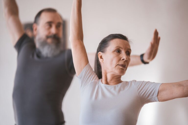 Un groupe pratique des mouvements d'étirement debout dans une salle claire